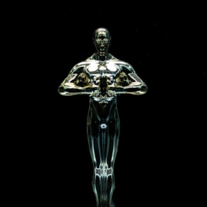 A golden trophy statue isolated on a black background symbolizing achievement and victory.